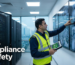 A professional photograph of a uniformed security engineer in a high-vis vest standing in a modern Dubai server room. He is pointing at a wall of monitors displaying CCTV feeds while holding a digital checklist tablet. The screen shows 'System Compliant'. Background is sleek and corporate. Lighting is bright and professional. Overlay text style: 'SIRA Compliance & Safety